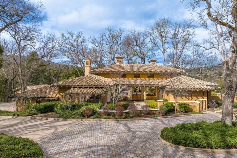A front exterior photo of a home surrounded by trees and bushes on 38 Arroyo Sequoia at the Santa Lucia Preserve.